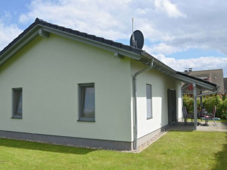 Ein modernes, helles Ferienhaus mit Garten und Satellitenschüssel.