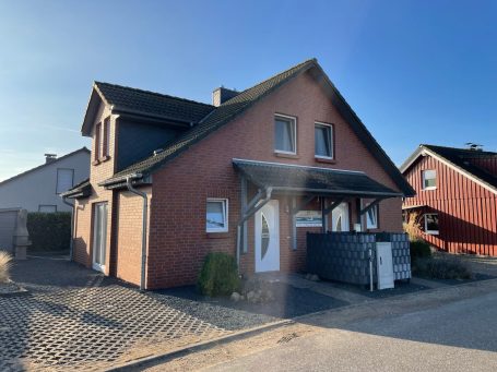 Ein modernes, helles Ferienhaus mit Garten und Satellitenschüssel.