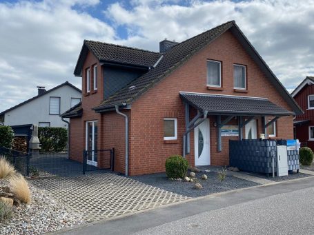 Ein modernes, helles Ferienhaus mit Garten und Satellitenschüssel.